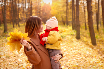  Mother and daughter having fun in autumn park. Happy family on walk. High quality photo