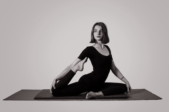 Joven mujer en bella postura en su mat de yoga. Pilates y actividades saludables. Fotografía en blanco y negro