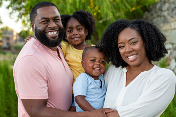 Happy African American family outside at a park.