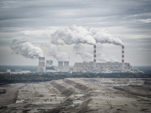 Aerial view of power plant and open-cast coal mine in Belchatow under moody cloudy sky, Poland