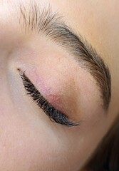 Close up of closed eyewith eyelash Extensions in beauty salon macro view