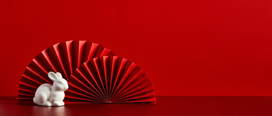 Red paper fans with figure of rabbit on red background. Chinese New Year holiday banner, Lunar New Year greeting card template. New Year of the Rabbit concept