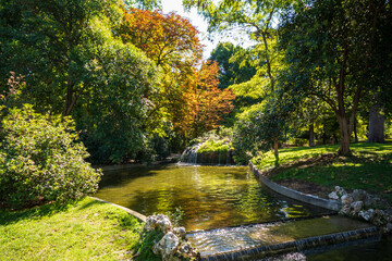 Dia soleado de oto&ntilde;o en el parque del Retiro del Madrid con las hojas aun verdes y sus famosos leones