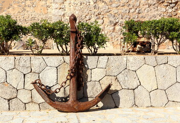 A lonely rusty anchor on the wall.