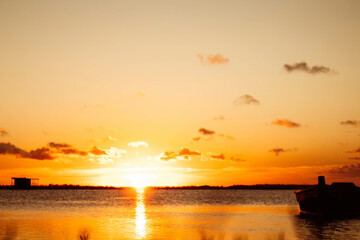 Abandoned boat in the sea at sunset
