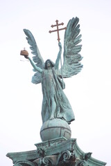 Statue on Budapest Heroes' Square. On the top of the column depicts Archangel Gabriel, who holds the Hungarian Holy Crown and the apostolic double cross in his hands