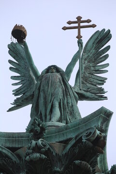 Statue on Budapest Heroes' Square. On the top of the column depicts Archangel Gabriel, who holds the Hungarian Holy Crown and the apostolic double cross in his hands