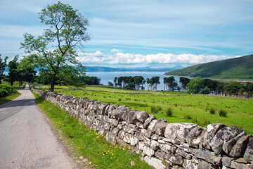 Fototapeta na wymiar Scottish country road with stone wall,leading to Applecross village,Highlands of Scotland,UK.