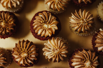 Top down shot of red velvet cupcakes with a brown caramel decorative creme icing on a golden platter