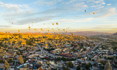 Spectacular drone view of hot air balloons ride over Turkey's iconic Cappadocia, the underground cities and fairy chimneys valley, rock formations, in the sunlight. High quality photo