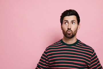 Obraz premium Handsome man blowing kiss on pink background. Space for text