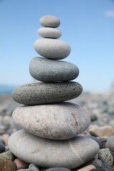 Fototapeta na wymiar Stack of stones on beach against blurred background, closeup