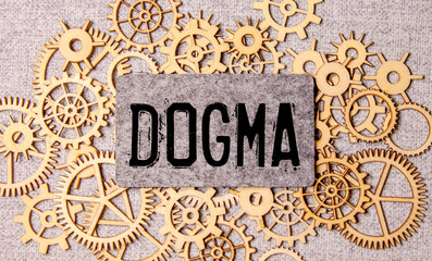 DOGMA text on the wooden block with notebooks ,keyboard with chart.