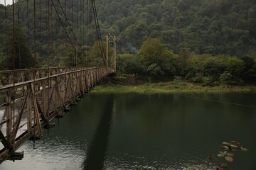 Fototapeta premium Beautiful view on rusty metal bridge over river in mountains