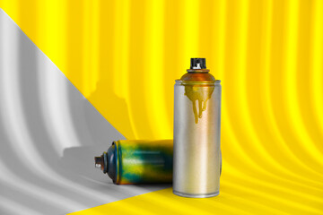 Used cans of spray paints on color background