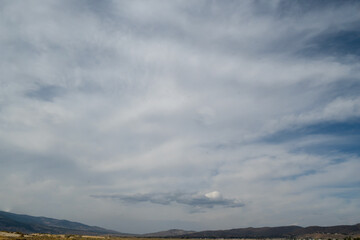 Washoe Lake State Park high desert landscape featuring a cloud in the distance on a blue sky day copy-space and green grass, Nevada, USA