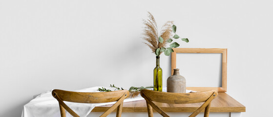 Wooden table with white cloth and beautiful floral decor in room