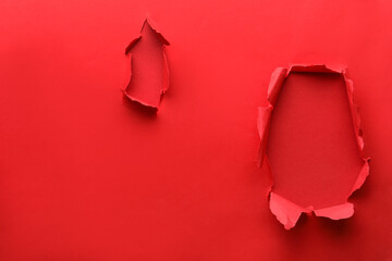 Holes in red paper on color background