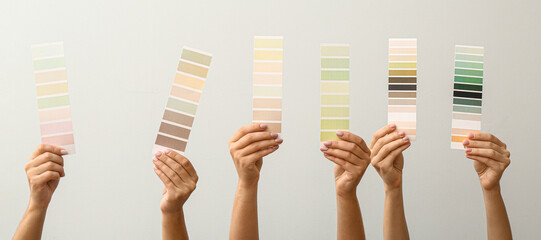 Female hands holding different color patterns on light background