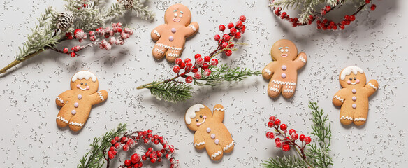 Fototapeta na wymiar Tasty Christmas cookies with rowan and fir branches on light background