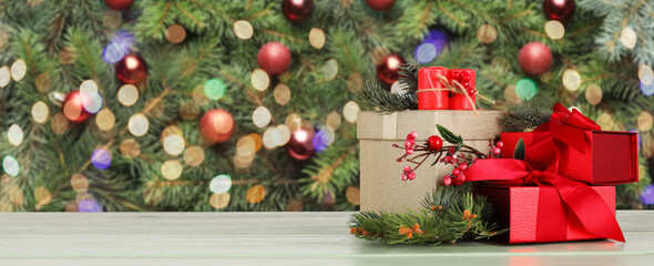 Fototapeta na wymiar Beautiful Christmas gift boxes, fir branches and candles on table