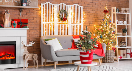 Interior of stylish living room with sofa, fireplace, Christmas trees and glowing lights