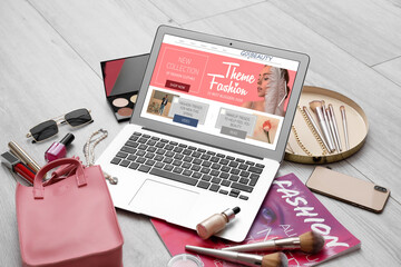 Laptop with open page of beauty blog, magazine, decorative cosmetics and accessories on light...