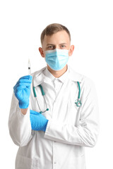 Male doctor in medical mask with syringe on white background