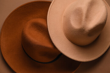Closeup view of stylish felt hats on brown background