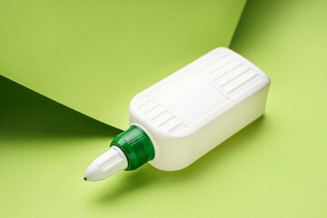 Bottle of glue on green background