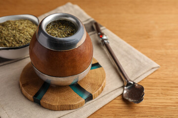 Calabash with mate tea and bombilla on wooden table