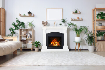 Fototapeta premium Stylish living room interior with fireplace, houseplants and beige sofa