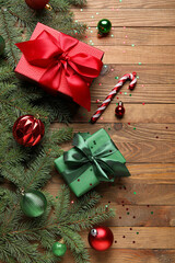 Composition with fir branches, Christmas decorations and gifts on wooden background