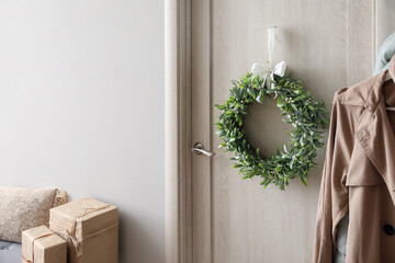 Christmas mistletoe wreath hanging on door in room