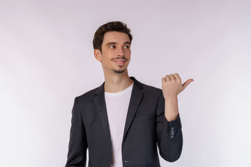 Portrait of young businessman pointing fingers at copy space isolated on white studio background