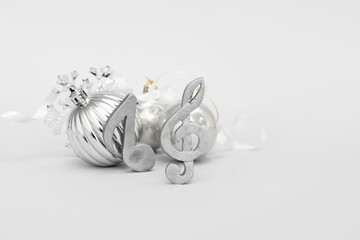 Note signs with Christmas balls, snowflake and ribbon on grey background