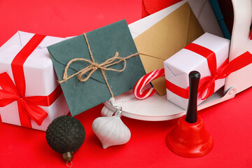 Letters to Santa with Christmas balls, presents and mailbox on red background, closeup