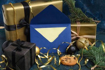 Letter to Santa with cookie, presents and Christmas decor on dark background