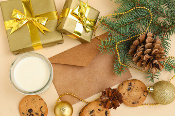Letter to Santa with glass of milk, cookies, presents and Christmas branches on beige background