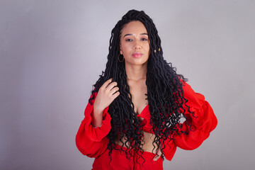 Beautiful black Brazilian woman, dressed in red. messing with the hair.