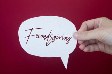 Speech bubble in front of colored background with Friendsgiving text.