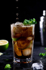 Cocktail with cola, decorated with lime slices