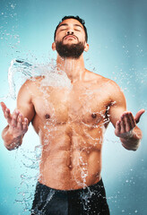 Body, shower and water with a muscle man in studio on a blue background for hygiene, hydration or...