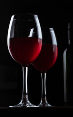 Glasses with red wine and bottle silhouette