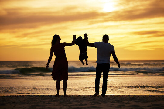 Beach silhouette, family holding child and sunset ocean holiday by waves, sand and summer sun background. Scenic travel vacation, relax by sea and swinging child together with love, care and freedom