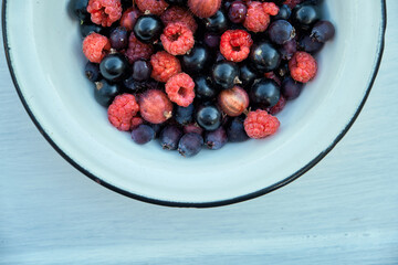 Variety ripe berries in rustic bowl on white background, top view. Organic superfood, summer dessert. healthy eating concept.