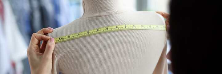Female fashion designer takes measurements with centimeter - Powered by Adobe