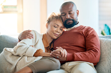 Love, relax and trust with a black couple on a sofa in the living room of their home together. Hug, marriage and romance with a mature man and woman bonding in the lounge of a house for calm peace