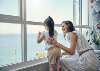 Family view, window and mother with child bonding, having fun and enjoy quality time together in home living room. Mamas love, happiness and mom with kid girl watch the ocean through glass window
