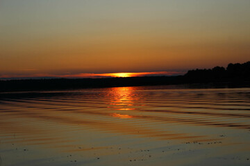 Fototapeta na wymiar Evening twilight. Sunset on the lake water surface
